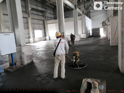 Worker power-floating a factory floor
