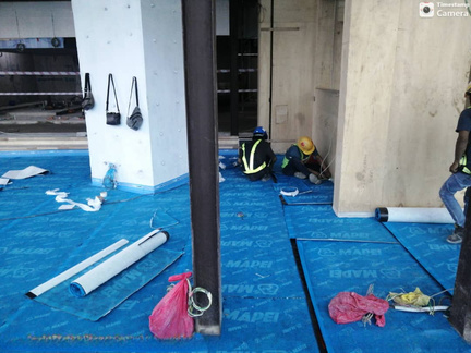 Blue sound-proof membrane laid across a floor slab