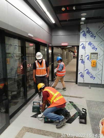 Crew installing touch-voltage membrane at a rail station platform